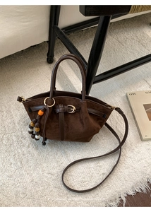 Détail du sac à main en daim marron foncé avec pendentif perles colorées et sangle