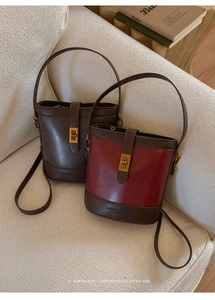 Detail of vintage matte bucket bags with golden twist locks and adjustable shoulder straps