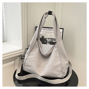 Detail of silver grey woven tote bag with wide adjustable shoulder strap and texture