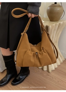 Detailed view of dark mustard hobo bag with drawstring pocket and minimalist retro vibe