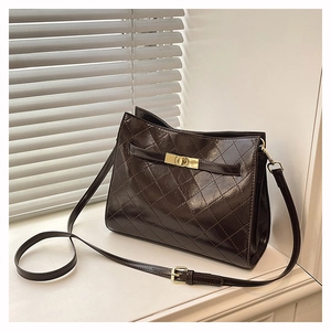 Detail of vintage brown quilted shoulder bag with shiny finish and gold rotating lock