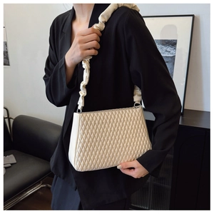 Detail view of the quilted rhombic pattern and cream white cloud scrunchie strap