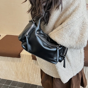 Detail of black multi-zipper crossbody bag with PU leather pulls and functional pockets