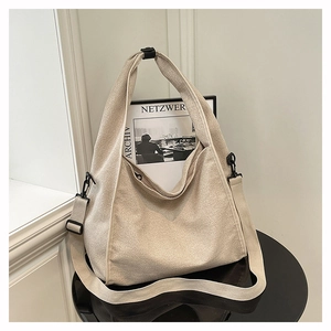 Detail view of the thick cream canvas texture and black metal buckle on the hobo bag