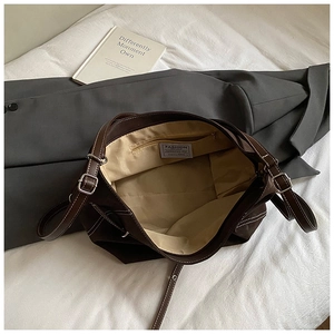Detail view of the spacious inner compartment and adjustable strap on a vintage brown tote bag