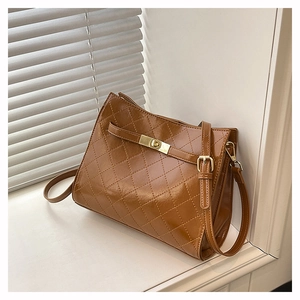 Detail of vintage brown quilted leather shoulder bag with golden twist lock closure