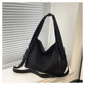 Detail of black hobo tote bag showing adjustable strap and durable twill fabric texture