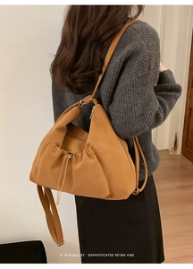 Minimalist camel leather underarm bag with drawstring folds and slim shoulder strap detail