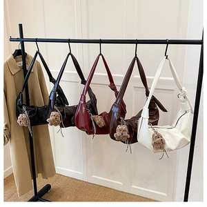 Detail of gathered hobo bags in five colors with cute teddy bear charms and knotted straps
