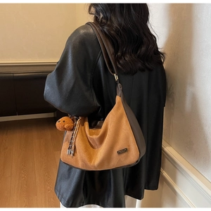 Mannequin portant un sac croissant rétro marron avec charm d'ours en peluche