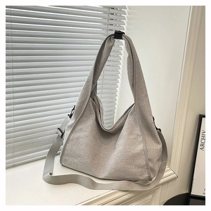 Detailed view of large grey tote bag with woven texture and adjustable shoulder straps