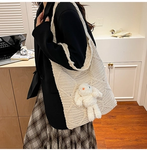 Close-up of knit tote bag with a 3D diamond pattern and cute white plush rabbit doll