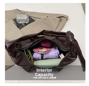 Internal capacity of dark brown leather tote bag showing umbrella and thermos inside