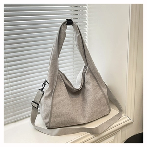 Close-up of grey hobo bag showing pebbled texture and adjustable fabric shoulder strap