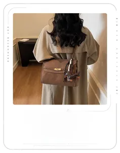 Brown vintage suede tote bag with scarf handle and dachshund charm in a home setting
