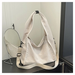 Macro detail of textured canvas tote with wide strap and black metal hardware