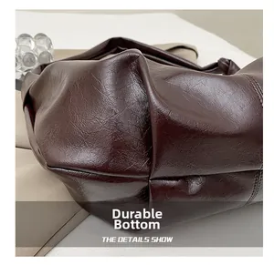Macro shot of durable bottom on dark brown pleated bag with reinforced stitching