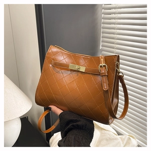 Detail of brown quilted faux leather underarm bag with gold metal twist lock buckle