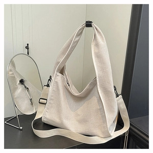 Close-up of oatmeal canvas tote bag with black hardware and thick texture detail