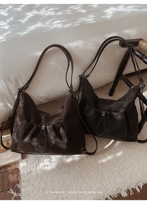 Close-up of retro hobo bags in coffee and black with metal drawstring pocket details