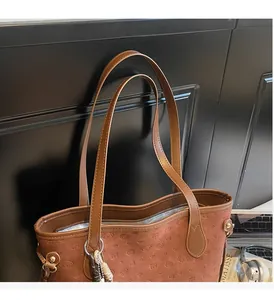 Close-up of vintage brown tote bag featuring embossed dog patterns and sturdy handles