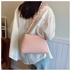 Close-up of pink quilted crossbody bag featuring a unique gathered ruched shoulder strap