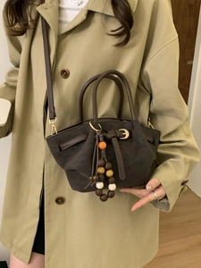 Vintage dark brown matte tote bag with wooden bead pendant shown on a trench coat model