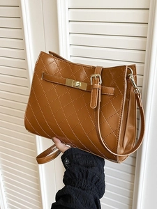 Chic brown quilted underarm bag with gold turn-lock and adjustable shoulder strap