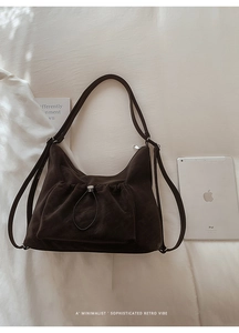 Detail of a brown suede retro backpack on white bedding with minimalist aesthetic