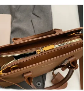 Detailansicht des glatten Metallreißverschlusses und der Lederstruktur der braunen Tasche
