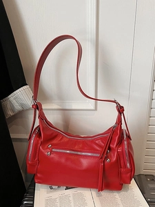 Retro red cylindrical shoulder bag with silver metallic zippers and punk rivets