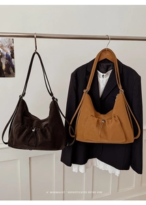 Detail of minimalist crescent shoulder bags in dark brown and caramel leather finish