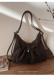 Detail of vintage dark brown suede handbag with drawstring pocket and matte texture