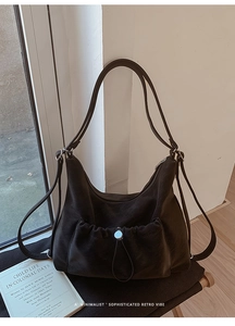 Detailed view of vintage suede hobo bag featuring a front drawstring pocket and silver buckle