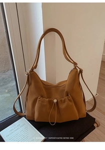 Detail view of caramel brown suede tote bag with drawstring pocket and versatile straps