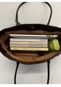 Spacious interior of brown tote bag holding tablet, books, and umbrella for daily use