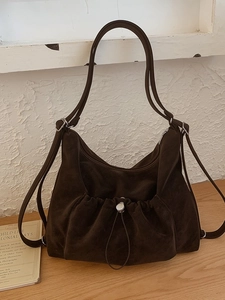Elegant dark coffee faux suede tote bag with drawstring pocket on wooden table