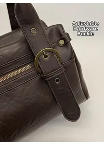 Détail de la texture cuir marron foncé avec boucle métallique réglable en bronze