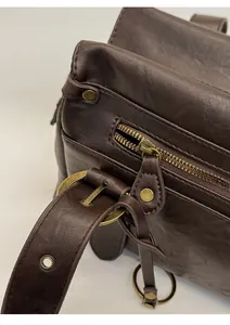 Détails macro de la quincaillerie en bronze vintage et fermeture éclair sur sac en cuir brun
