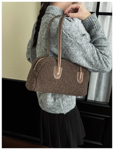 Détail de la texture en peau de mouton marron et de la bandoulière en cuir du sac bowling