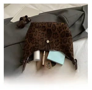 Dettaglio della capacità interna della borsa hobo leopardata con oggetti quotidiani