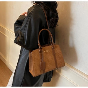 Nahaufnahme der braunen Vintage-Tasche mit Leder-Mix und Details der Markenbeschläge
