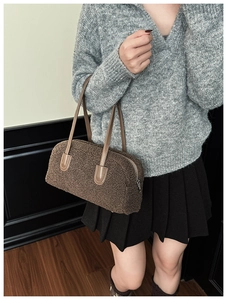 Sac hobo en polaire marron porté par un mannequin avec poignée en cuir et zip supérieur