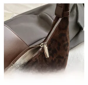 Dettaglio macro della borsa vellutata leopardata con robusta cerniera in metallo argento