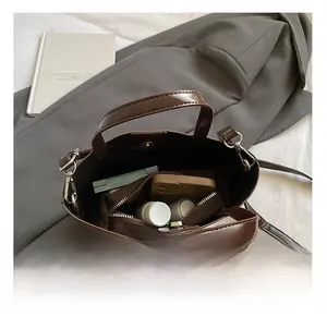 Detail view of brown glossy bucket bag interior showing spacious pockets and organizer