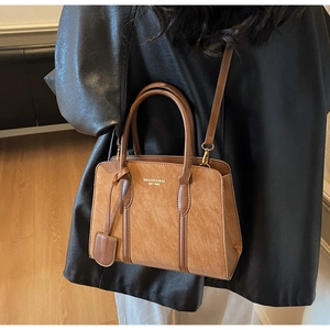 Detail der Vintage-Tragetasche Textur und MKAXIQI & BAG EST 1985 Schriftzug in Braun