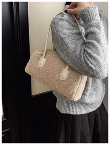 Détail de la texture en peau de mouton beige et bandoulière en cuir du sac