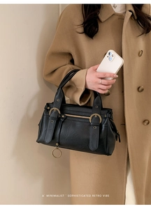 Détails du sac vintage en cuir noir avec boucles en bronze et éléments métalliques