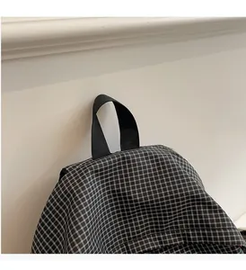 Close-up of durable black nylon handle and checkered fabric detail on backpack