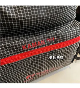 Detail of classic black and white plaid canvas backpack with red zipper and brand logo